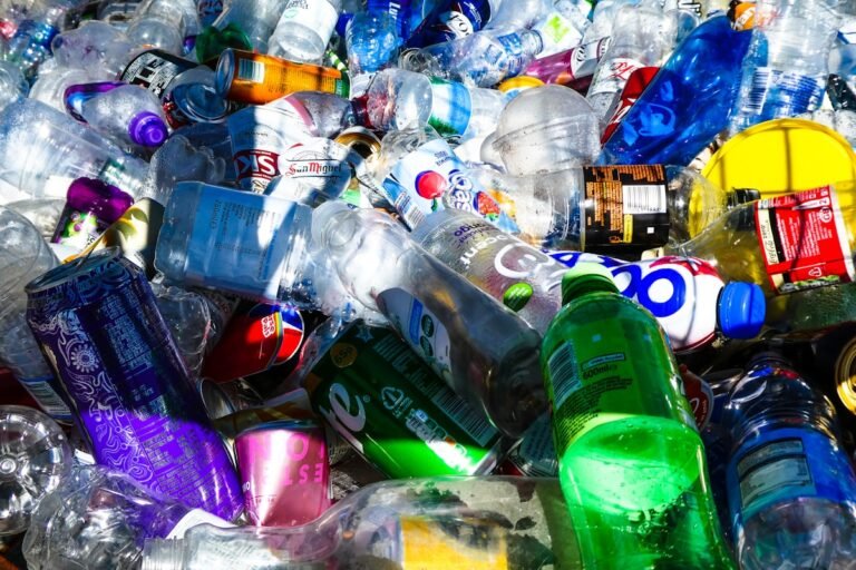 A large pile of discarded plastic bottles and aluminium cans for recycling