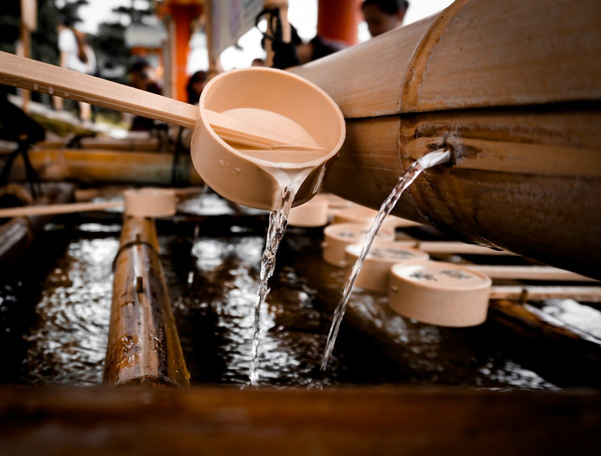 water pouring from brown wooden bucket